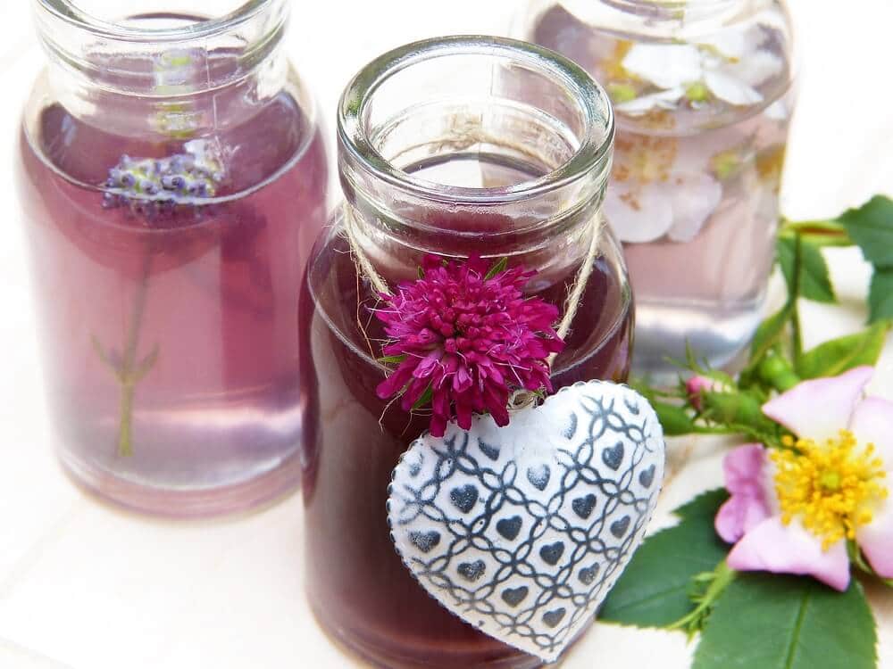 Three different types of essential oils with flowers