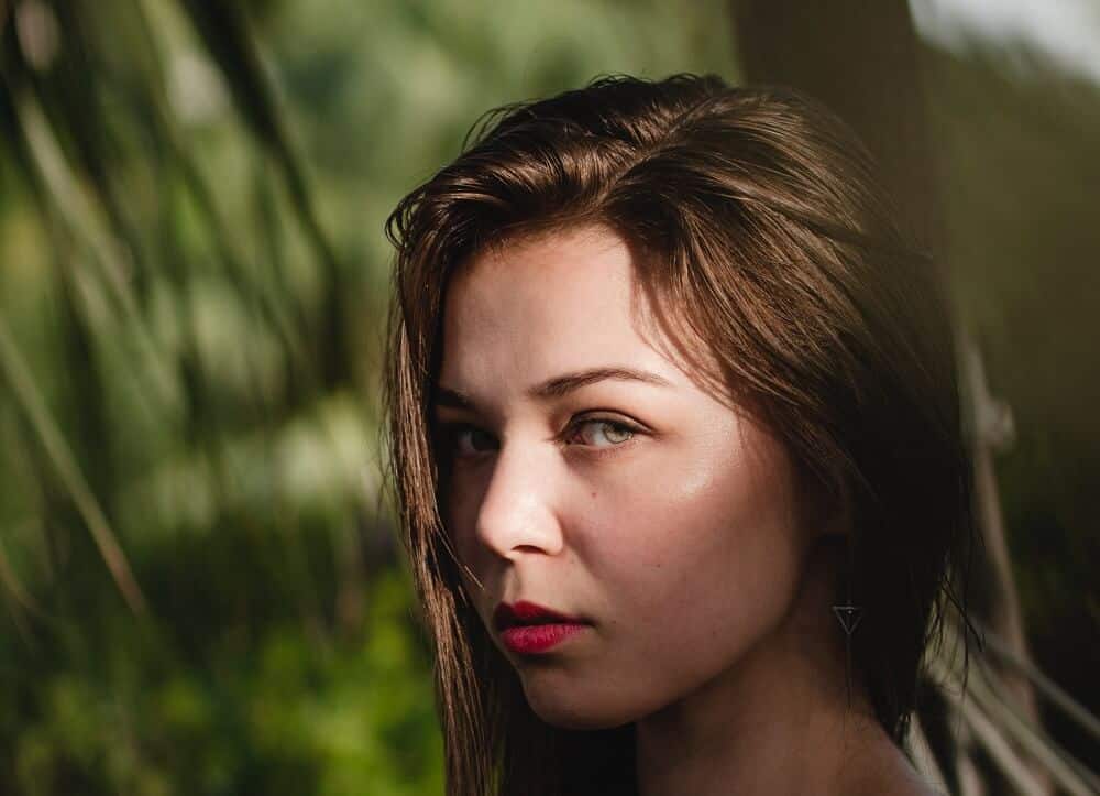 Beautiful girl with clear skin on green forest background